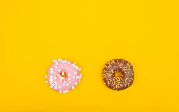 Zoete donuts op gele achtergrond. Dessert voedsel — Stockfoto