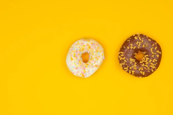 Zoete donuts op gele achtergrond. Dessert voedsel — Stockfoto
