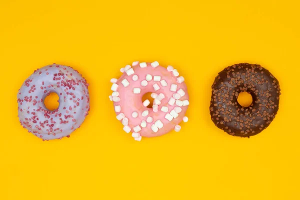 노란색 배경에는 달콤 한 도넛 이 있습니다. 음식을 배급함 — 스톡 사진