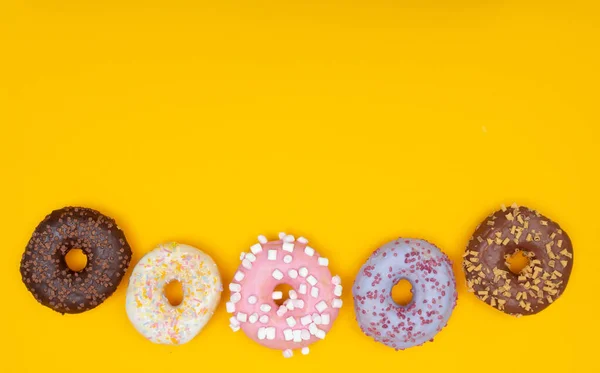 노란색 배경에는 달콤 한 도넛 이 있습니다. 음식을 배급함 — 스톡 사진