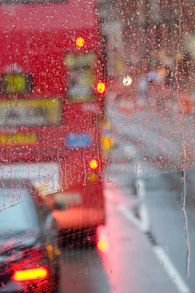 Londra görünümünde kırmızı otobüs pencereden yağmur specked yağmur — Stok fotoğraf