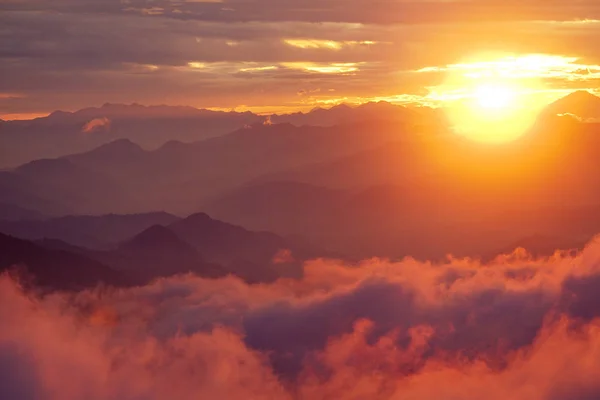 Oranje zonsondergang boven de berg in vallei Himalaya gebergte — Stockfoto