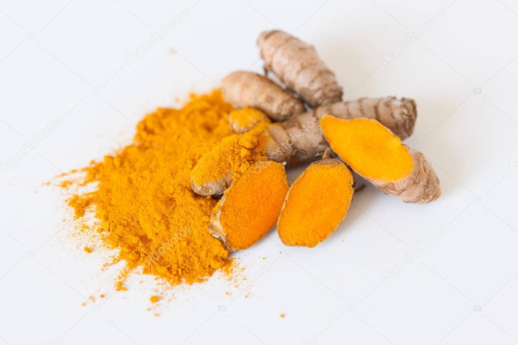 Turmeric roots with turmeric powder isolated on white background