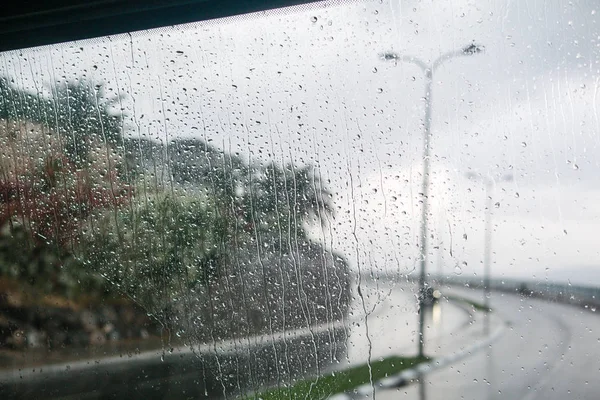 Cena de rua embaçada através de janelas de carro com gota de chuva — Fotografia de Stock