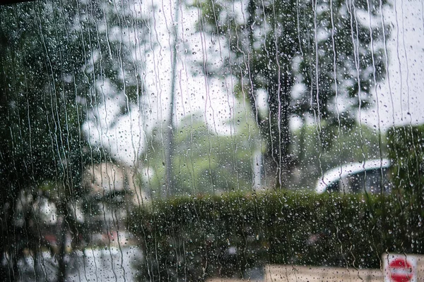 透过车窗与雨滴模糊的街道场景 — 图库照片