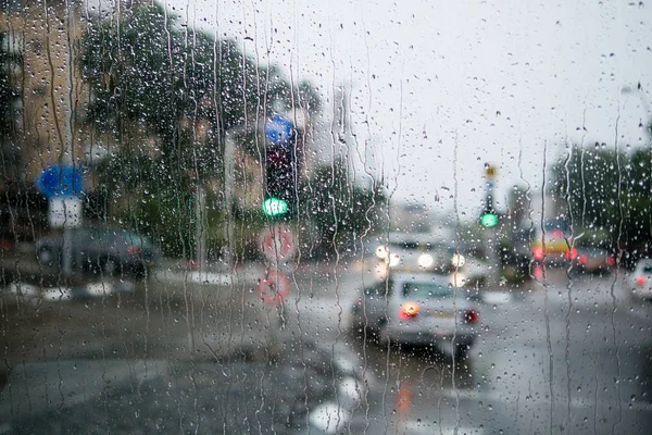 Scena di strada offuscata attraverso i finestrini dell'auto con goccia di pioggia — Foto Stock