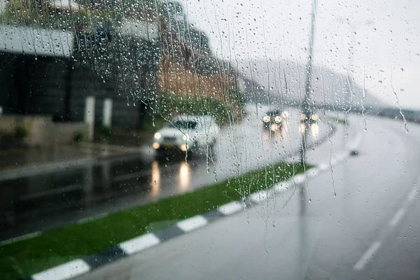 Suddig gatubilden genom bilfönster med regn släpp — Stockfoto