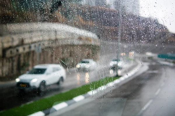 Escena de calle borrosa a través de ventanas de coche con gota de lluvia — Foto de Stock