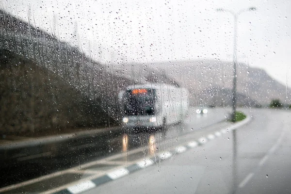 Cena de rua embaçada através de janelas de carro com gota de chuva — Fotografia de Stock