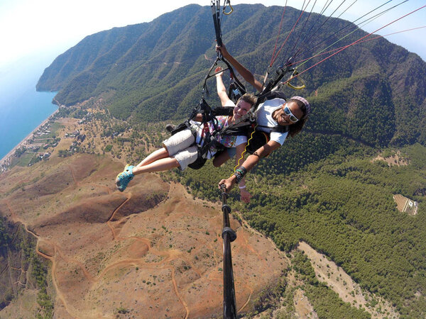 АДРАСАН, ТУРКЕЙ - 27 июня 2017 года: Параглайдинг над лагуной
