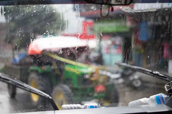 Blurred street scene through car windows with rain drop in Nepal