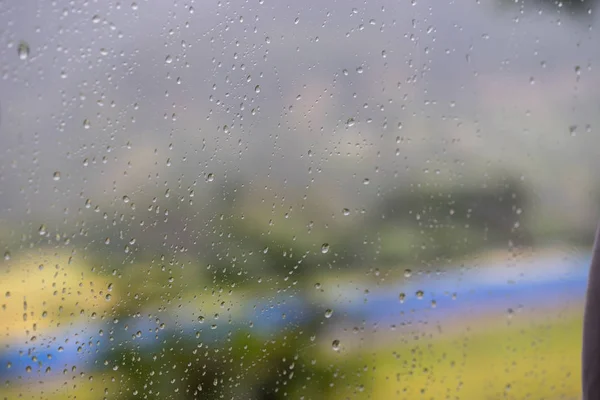 Scena di strada offuscata attraverso i finestrini dell'auto con caduta di pioggia in Nepal — Foto Stock