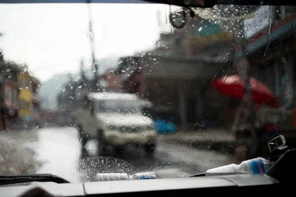 Cena de rua embaçada através de janelas de carro com gota de chuva no Nepal — Fotografia de Stock