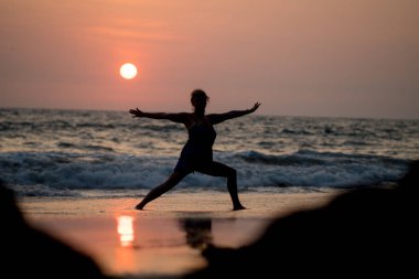Okyanus maliyet ve gün batımı Hindistan Yoga siluet