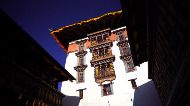 Templo Dzong y banderas de oración religiosa en el valle, Bután — Vídeo de stock