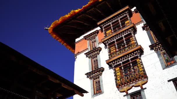 Tempel Dzong en religieuze gebedsvlaggen in de vallei, Bhutan — Stockvideo