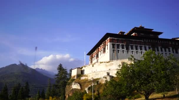 Tempel Dzong und religiöse Gebetsfahnen im Tal, Bhutan — Stockvideo