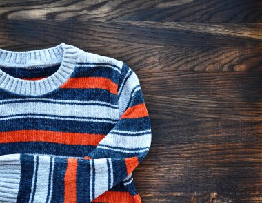 Ahşap arka plan çizgili süveter. Üstten Görünüm.