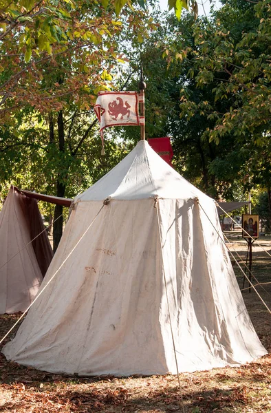 Canvas tent in ancient style with flag on medieval fair
