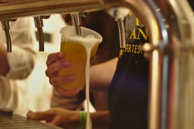 Barmen plastik bardakta köpüksüz bira servisi yapıyor..