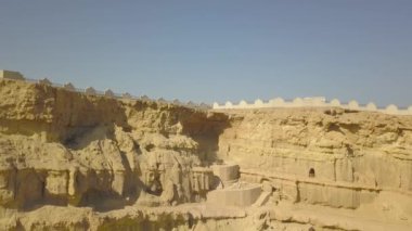 Khorbas Mağara kompleksi Keshm, İran 'ın güney kıyısında yer almaktadır. İnsansız hava aracı, tarihi bir bölgede uçan bir video çeker. Kayalardaki mağaraları, çitleri görebilirsin..