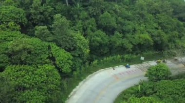 Phuket, Tayland 'daki panoramik orman manzarası. Bir dron orman yolunda uçuyor, hareket eden motorsikletleri, ormanı, palmiyeleri, yolları, ATV 'leri görebileceğiniz yerde..