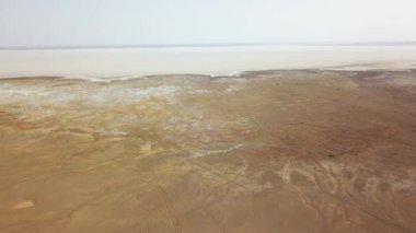 Maranjob çölünün panoramik üst görüntüsü. İHA tuz gölü Namak 'a yaklaşıyor. Görünür tuz, tekerlek izleri ve kumdaki develerin izleri.