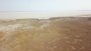 Maranjob Çölü 'nün panoramik manzarası. Drone yavaşça Namak Gölü 'nden uzaklaşıyor. Görünür tuz, tekerlek izleri ve kumdaki develerin izleri..