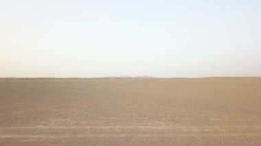 Maranjob Çölü 'nün panoramik manzarası. Bir İHA kumların ve kumulların üzerinden uçuyor. Kumda görülebilir tuz ve açık mavi gökyüzü