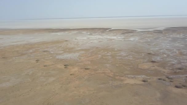 Vue panoramique sur le désert de Maranjob. Le drone s'envole lentement du lac salé desséché Namak. Sel visible, fissures sèches et ciel bleu clair 