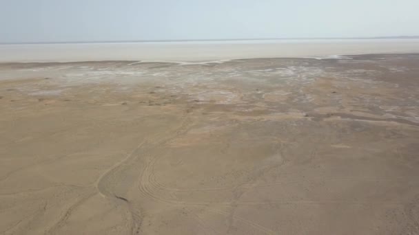 Vue panoramique sur le désert de Maranjob. Le drone s'envole lentement du lac salé desséché Namak. Sel visible et marques de roue dans le sable 