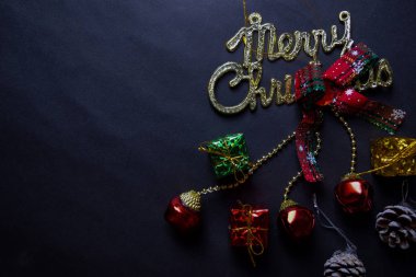 Mutlu Noeller mesajı ve dekoratif Noel siyah arka planda izole edilmiş.