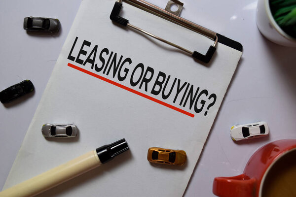 Лизинг или покупка? писать на бумаге с автомобильными игрушками изолированы на белом фоне доски
.