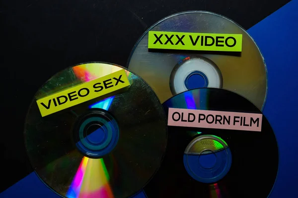 Staré filmy sex video v kompaktní disk izolované na pozadí stolu — Stock fotografie