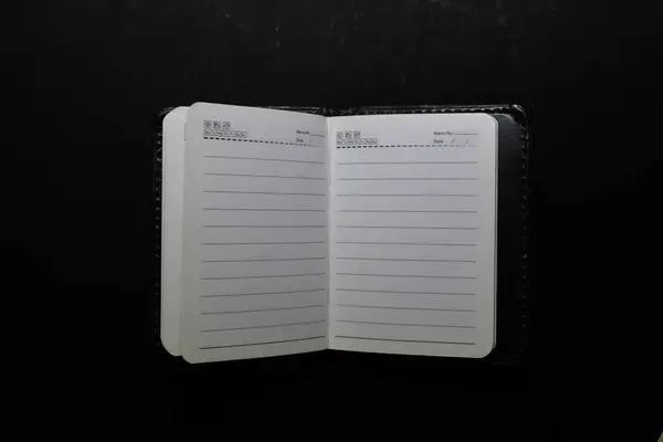 Close up white notebook isolated on black background — Stockfoto