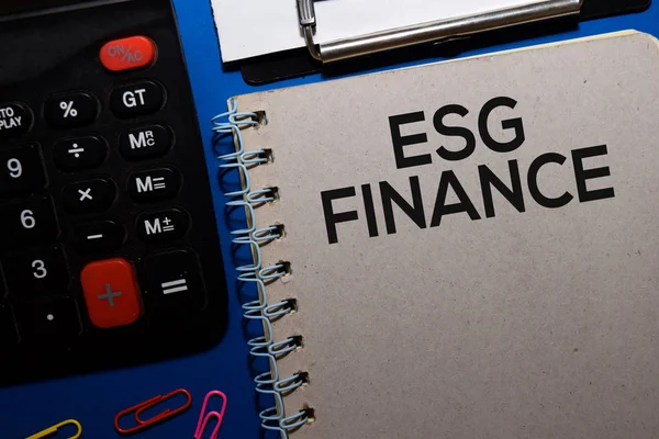 ESG Finance пише на книжках ізольованих на дерев'яному столі. Медичне або фінансове поняття — стокове фото