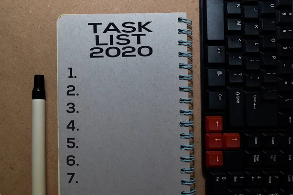 Task List 2020 write on Book. Isolated on office desk background