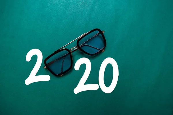 Feliz Año Nuevo 2020 con gafas aisladas en la mesa de color —  Fotos de Stock
