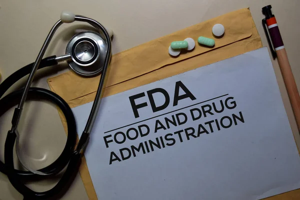 FDA - Food and Drug Administration texto no documento acima envelope marrom e estetoscópio. Conceito de saúde ou médico — Fotografia de Stock