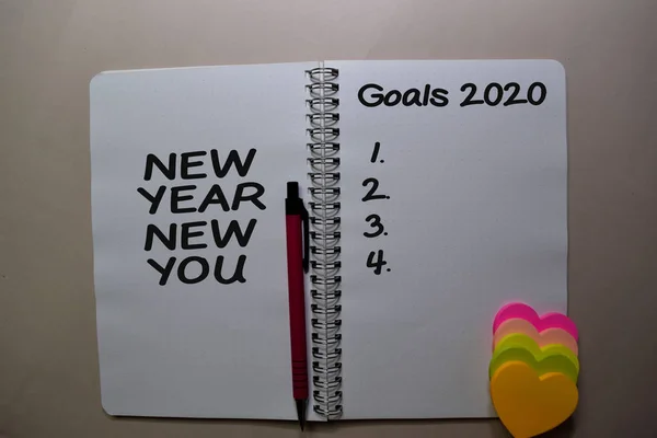 新年与2020年目标写在写字台上的一本书上 — 图库照片