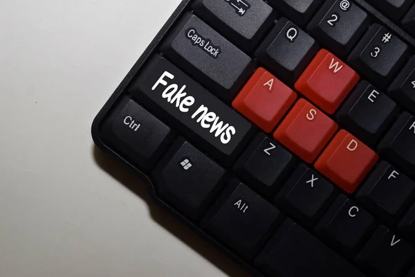 Fake News пише на клавіатурі ізольованих на ноутбуці — стокове фото