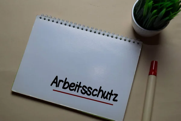 Az Arbeitsschutz egy irodai asztalon elkülönített könyvre ír. Német nyelv azt jelenti, munkahelyi biztonság — Stock Fotó