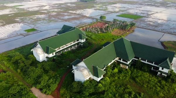 Aerial, Drone Shot, em cima na fazenda abandonada cercada por arrozal, na cidade de Bekasi, em um dia ensolarado de verão, na Indonésia . — Fotografia de Stock