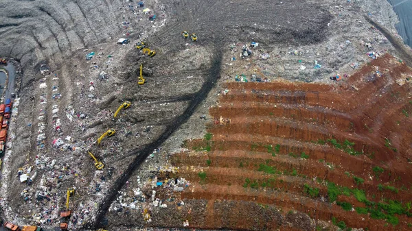 空中展望。山のような大規模な埋め立て。トラクターはベカシの埋め立て地でゴミを取ります-インドネシア — ストック写真
