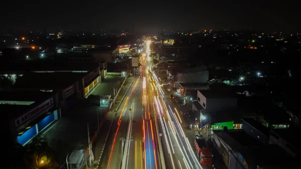 Trilhas de luz na auto-estrada à noite, exposição longa abstrato fundo urbano em Bekasi — Fotografia de Stock