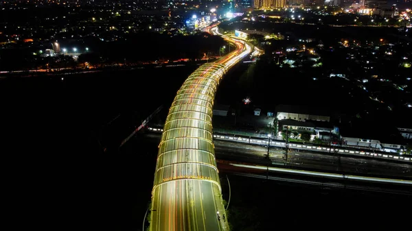 Bekasi, West Java, Indonésia - 10 de fevereiro de 2020: trilhas de luz na rodovia à noite, exposição longa abstrata fundo urbano em Summarecon Bekasi — Fotografia de Stock