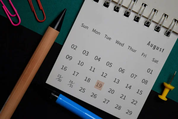 Ovanifrån Augusti månad Kalender och markerade 19: e flygdag isolerad på skrivbord — Stockfoto
