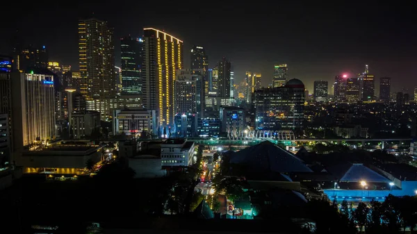 Bekasi, 18 lutego 2020: Nowoczesne budynki Dżakarty ze światłami w nocy na tle, widok z Kuningan Dżakarta, Indonezja — Zdjęcie stockowe