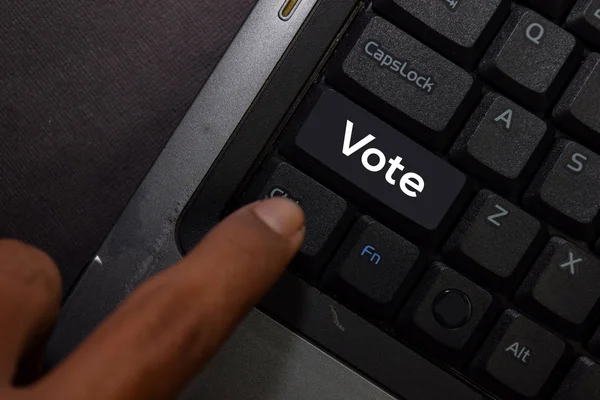 Голосование изолировано на фоне клавиатуры ноутбука — стоковое фото