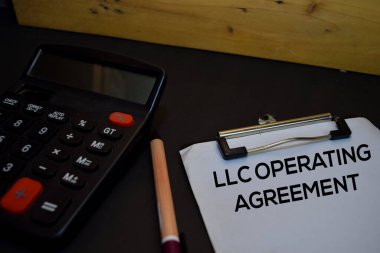 Llc İşletme Anlaşması, ahşap arka planda izole edilmiş bir evrak üzerine yazıldı.